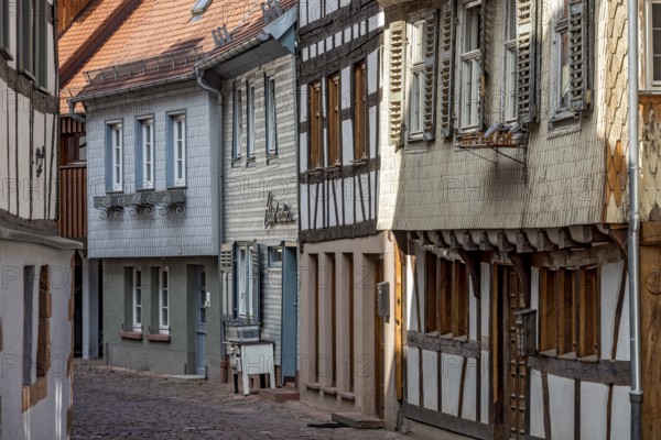 Row of houses with old half-timbered houses and clapboard houses, wooden shingles in pastel colours, narrow alley, historic old town, Michelstadt, Odenwald, Hesse, Germany, Europe