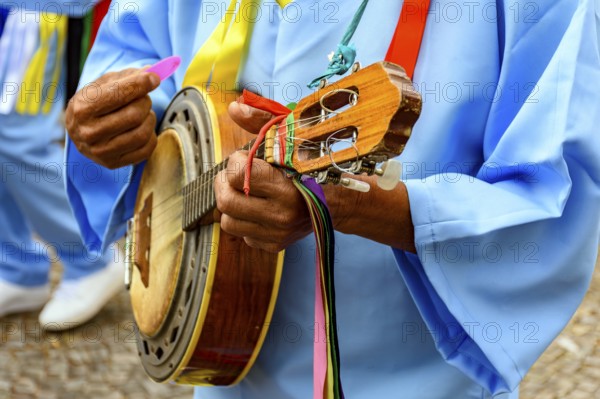 Hands of banjoist on the streets of Brazil wearing colorful clothes during a traditional religious festival, Belo Horizonte, Minas Gerais, Brazil, South America