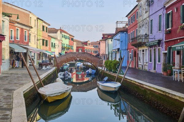 Colorful houses beside the waterway in between 'Fondamenta San Mauro' and 'Fondamenta degli Assassini' with boats lying in the water on the island of Burano, Italy, Europe