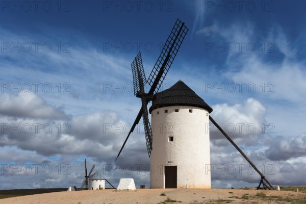 White windmill under a dramatic sky with other mills in the background, Campo de Criptana, Ciudad Real province, Castilla-La Mancha, Don Quixote Route, Spain, Europe