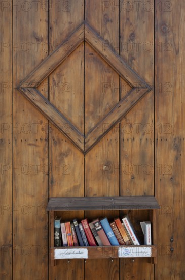Books to give away on a shelf on a wooden wall, Riegel am Kaiserstuhl, Baden-Württemberg, Germany, Europe