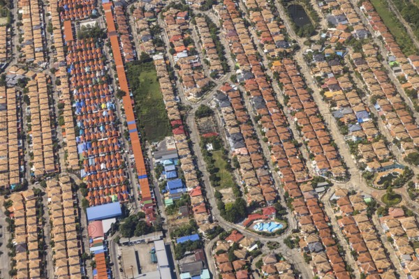 Retort city in the north-east of Bangkok. Standardised houses stand close together on the straight streets of a housing estate. Urban planning from the retort. Approaching Don Mueang Airport, Bangkok, Thailand, Asia