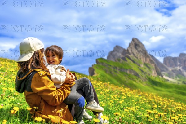 Mother holding her son while enjoying a summer day in the seceda mountains in the italian dolomites