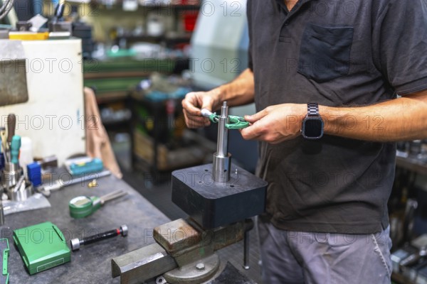Close-up of unrecongizable man measuring metal pieces using a micrometer in a cnc factory