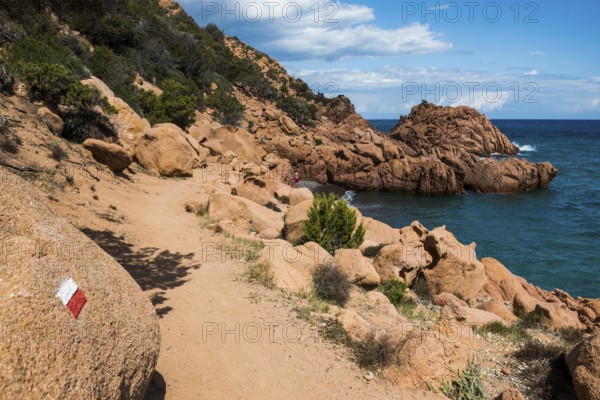 Hiking trail along the coast with red rocks and sea, Spiaggia di Coccorocci, near Tertenia, Province of Ogliastra, Sardinia, Italy, Europe