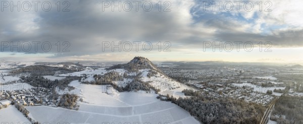 Aerial view, panorama of the snow-covered Hegau volcano Hohentwiel with Germany's largest castle ruins on a winter morning at sunrise, in front of it Germany's highest vineyard, the Elisabethenberg at 505 metres above sea level, on the right the town of Singen, on the left on the horizon the neighbouring Hegau volcano Hohenkrähen, district of Constance, Baden-Württemberg, Germany, Europe