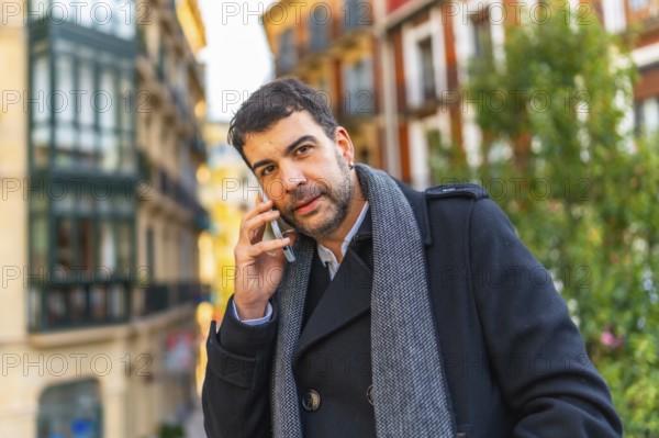 Close-up portrait of a handsome mature casual businessman talking to the mobile phone in the city