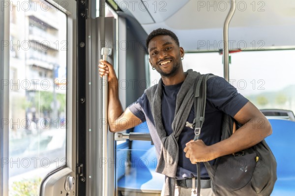 Confident handsome african student on the bus on the way to university