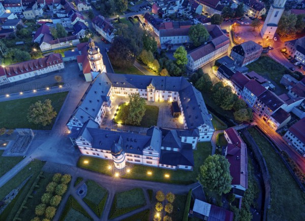 Ehrenstein Castle, a well-preserved Renaissance castle, with castle garden, illuminated at dusk. Aerial view. Ohrdruf, Thuringia, Germany, Europe
