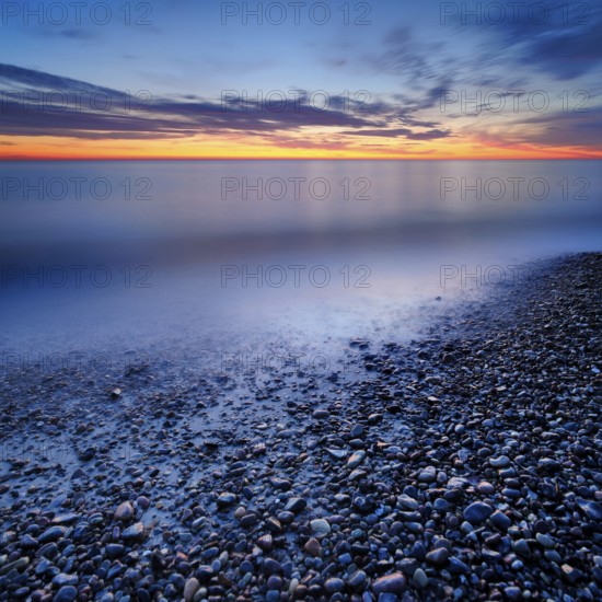 Pebbles in the water on the shore of the Baltic Sea at dusk after sunset, Weststrand Darß, peninsula Fischland-Darß-Zingst, National Park Vorpommersche Boddenlandschaft, Mecklenburg-Vorpommern, Germany, Europe