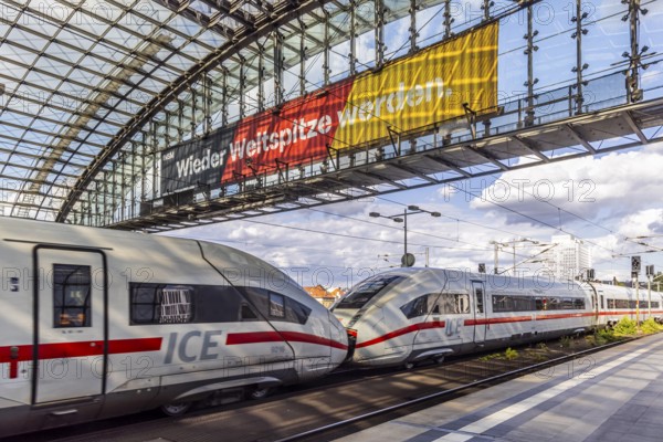Becoming world class again. ICE, Berlin, central station with platform hall with glass roof construction, banner with German flag and the slogan