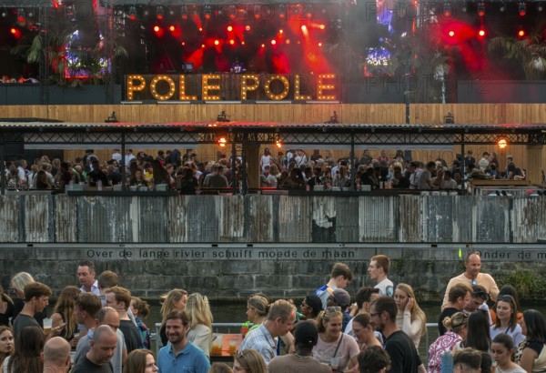 Spectators on grandstand at the Graslei watching Pole Pole podium during Gentse Feesten, Ghent city festival, summer festivities in Flanders, Belgium, Europe
