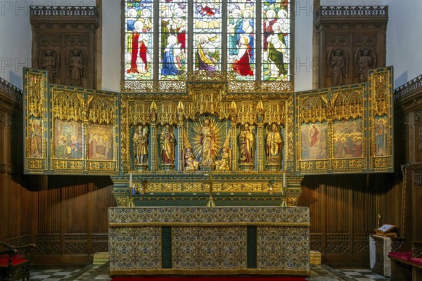 Elaborately carved gilt altar reredos screen 1938, church of Saint John the Baptist, Peterborough, Cambridgeshire, England, UK