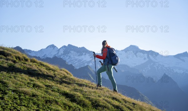 Hiker enjoying the mountain panorama in the morning, Venediger group, behind Dreiherrenkopf, Simonysitze and Großer Geiger, Hohen Tauern, Austria, Europe