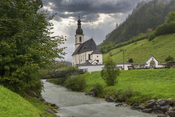 Parish church of St Sebastian, bridge, stream, rainy weather, Ramsauer Ache, Ramsau, Berchtesgadener Land, Upper Bavaria, Bavaria