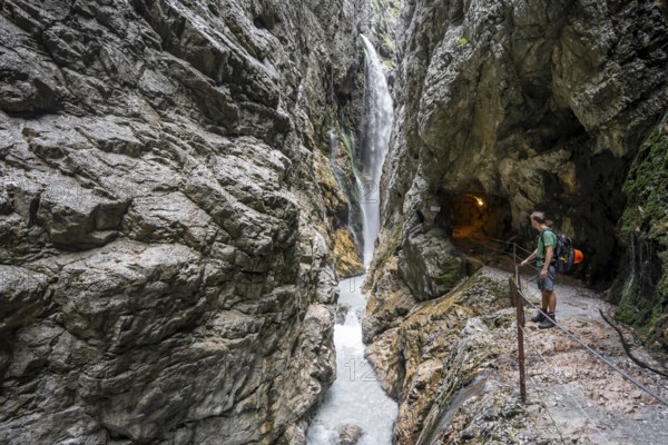 Waterfall and mountain stream Hammersbach in a canyon, mountaineers on a hiking trail in a gorge, Höllentalklamm, Höllental, Bavaria, Germany, Europe