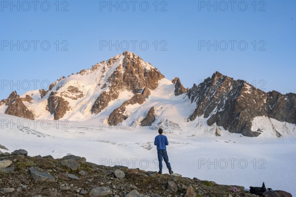 High alpine mountain landscape at sunset, Glacier du Tour, mountaineer in front of glacier and mountain peak, summit of Aiguille de Chardonnet, Chamonix, Haute-Savoie, France, Europe