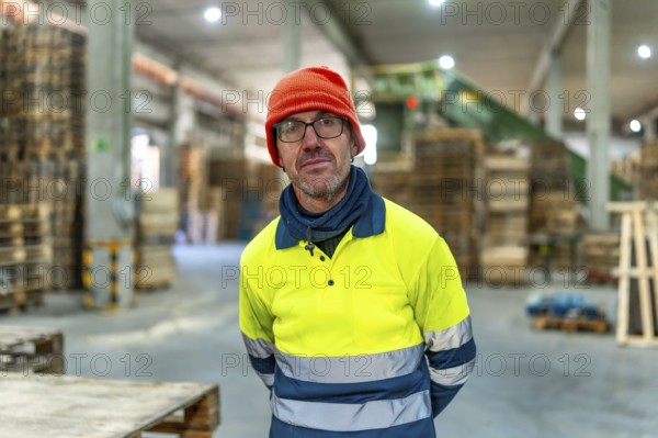 Portrait of a adult serious caucasian man carpenter standing working in a recycling plant