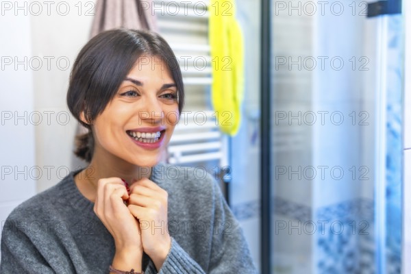 Satisfied woman looking how she looks with transparent brackets standing in the bathroom at home alone