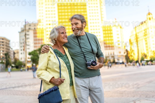 Senior modern couple walking in urban square visiting the city together
