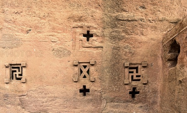 Cross-shaped windows carved in stone in the underground monolithic rock-hewn church of Biete Maryam, north side, UNESCO World Heritage Site Lalibela, Ethiopia, Africa