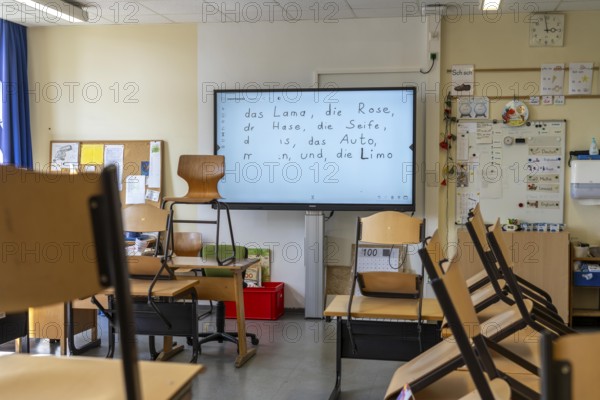 Classroom of a fourth grade, after school, the building is older but in good condition, modern teaching materials, interactive, digital whiteboard