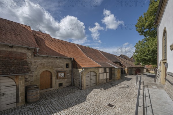 Inner courtyard with former church arcades, barns and St John's Church in the historic fortified church, Hüttenheim, Lower Franconia, Bavaria, Germany, Europe
