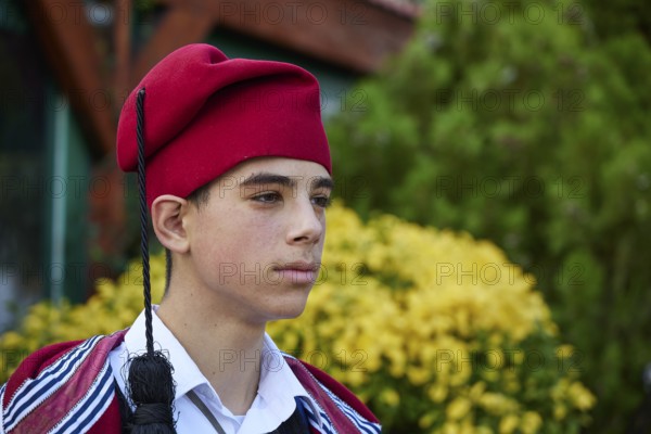 Side portrait of a boy in traditional Cretan traditional costume with a red hat outdoors, visit of Federal President Frank-Walter Steinmeier to Kandanos on 31 October 2024, Federal President, Frank-Walter Steinmeier, memorial, war crimes, Nazis, Wehrmacht crimes, World War II, Kandanos, southwest Crete, Crete, Greek islands, Greece, Europe