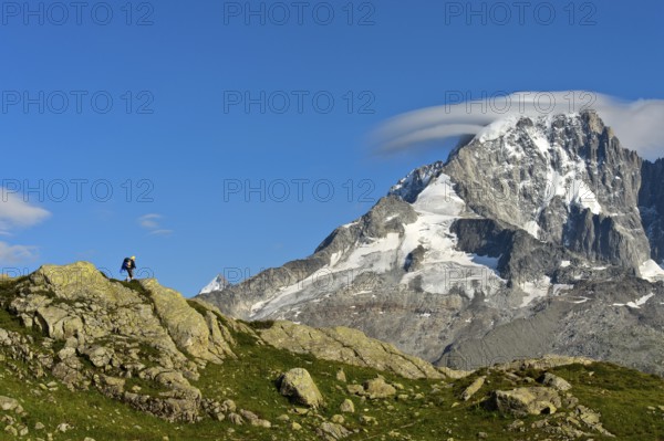 Hikers in the Aiguilles Rouges nature reserve against the impressive backdrop of the summit of the Aiguille Verte, Chamonix, Haute Savoie, France, Europe
