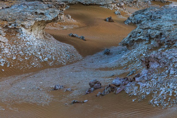 Striking cliffs surrounded by windswept sand structures, Huqf stone desert, Arabian Peninsula, Sultanate of Oman