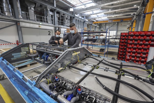 Herten, North Rhine-Westphalia, Germany, Cummins Hydrogenics fuel cell factory. Employees assemble fuel cell systems for Alstom's Coradia iLint hydrogen trains. The Coradia iLint is the world's first passenger train to be powered by a hydrogen fuel cell, which generates electrical energy for propulsion. Six fuel cell modules are installed on each train (right in the picture) . Note: The people pictured have given their verbal consent for publication in the press, Europe