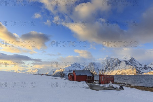 Red boathouses, coast, snowy mountains, fjord, morning light, clouds, snow, Lyngen Alps, Norway, Europe