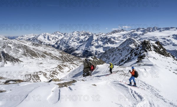 Ski tourers descending from the summit of the Madritschspitze, mountain panorama with snow-covered mountain landscape in winter, Ortler Alps, Vinschgau Valley, Italy, Europe