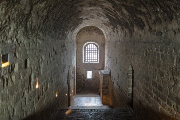 Dark stone corridor with lattice window in medieval style, Le Mont-Saint-Michel