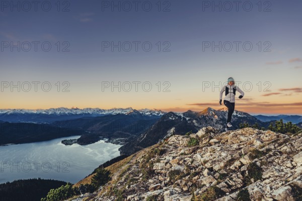 Trail running in autumn on the Jochberg on Lake Walchensee against the wonderful backdrop of the Alps, Bavaria, Germany, Europe