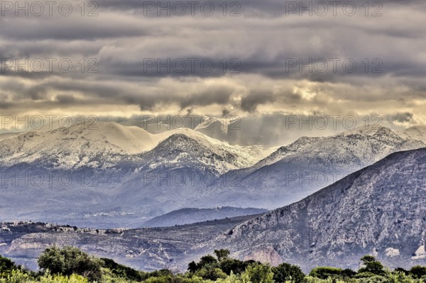 Snowy mountains under threatening grey clouds in a vast landscape with a dramatic atmosphere, Lefka Ori, White Mountains, mountain massif, West, Crete, Greece, Europe