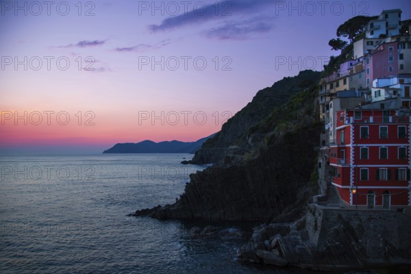 Italy, Riomaggiore colorful buildings overlooking scenic shoreline. Cinque Terre landscapes in Italy on Amalfi Coast, Europe