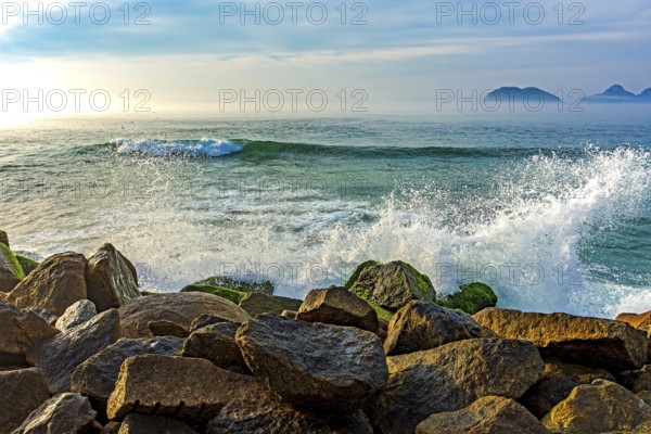 Waves crashing against the rocks of the Barra da Tijuca breakwater during dawn in Rio de Janeiro Rio de Janeiro, RJ, Brazil, South America