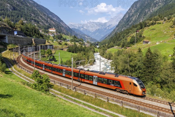 Railway passenger train of the type Stadler Flirt of the Südostbahn on the Gotthard railway in the Alps in Wassen, Switzerland, Europe