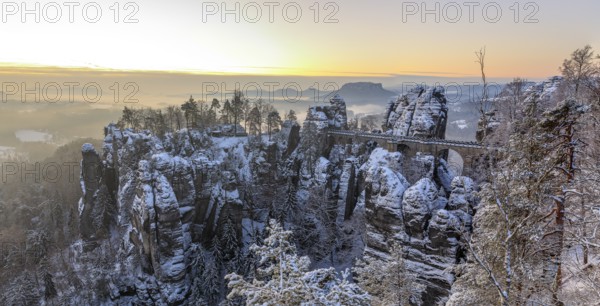 Snow-covered rock castle Neurathen and Bastei bridge in the morning, in the background the Lilienstein, Saxon Switzerland, Saxony, Germany, Europe