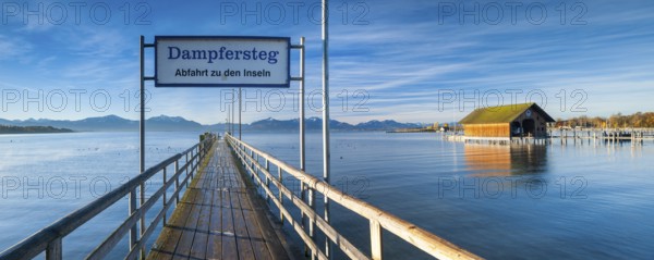 Steamer jetty and boathouse on Lake Chiemsee in autumn in the morning light, behind the Chiemgau Alps, Chiemgau, Bavaria, Germany, Europe