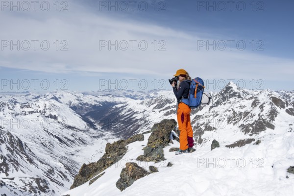 Photographer taking pictures at the summit, Scalettahorn, snow-covered mountains, winter in the Albula Alps, Graubünden, Switzerland, Europe