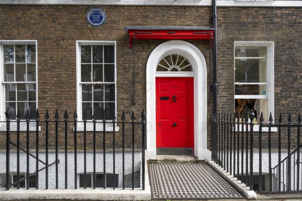 Red entrance door in a brick building with a cast-iron fence, Charles Dickens Museum, 48-49 Doughty Street, Holborn, London Borough of Camden, England, United Kingdom, Europe