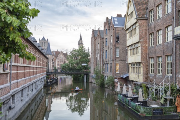 Brick building along a canal with boat, in evening atmosphere, Ghent