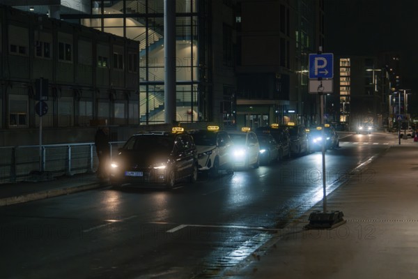 Series of taxis parked on a quiet and illuminated street at night, Stuttgart, Germany, Europe