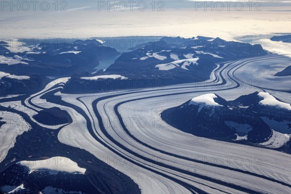 Aerial view of glaciers, glacier tongues and icy mountains on the coast, sunny, East Greenland, Greenland, North America