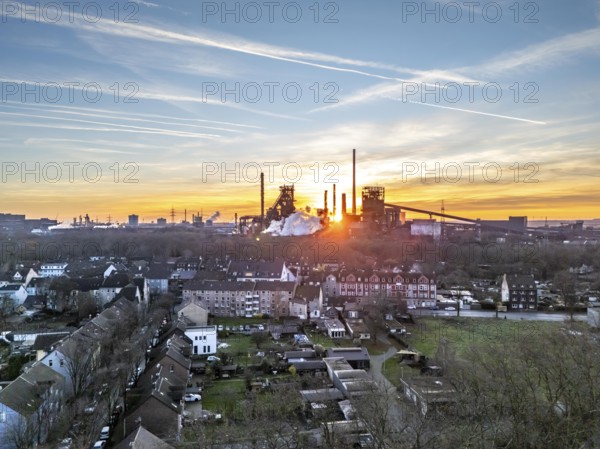 Blast furnaces Schwelgern 1 and 2, residential buildings in Duisburg-Marxloh, ThyssenKrupp Steel, sunset, Duisburg, North Rhine-Westphalia, Germany, Europe