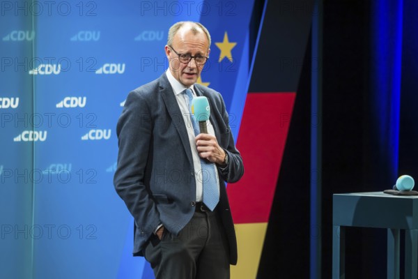 Election event of the CDU party for the Bundestag elections with top candidate Friedrich Merz. Portrait in front of the German flag and the flag of the European Union. Singen am Hohentwiehl. Baden-Württemberg, Germany, Europe