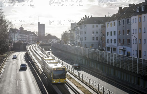 Essen, North Rhine-Westphalia, Germany - Cars and a public bus drive on the A40 motorway through the city centre of Essen, behind the Westenergie Tower, former RWE Tower