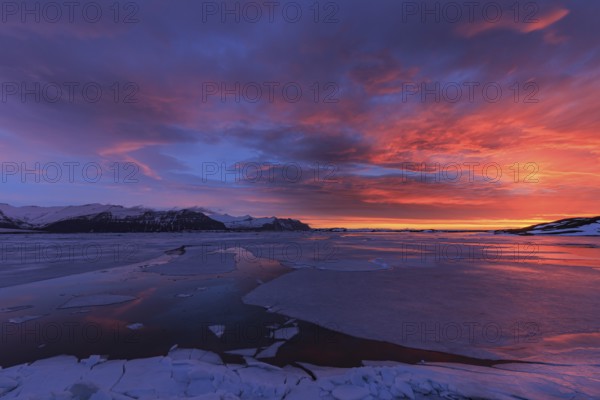 Dawn over frozen lake and mountains, winter, Jökulsarlon, Vatnajökull, Iceland, Europe